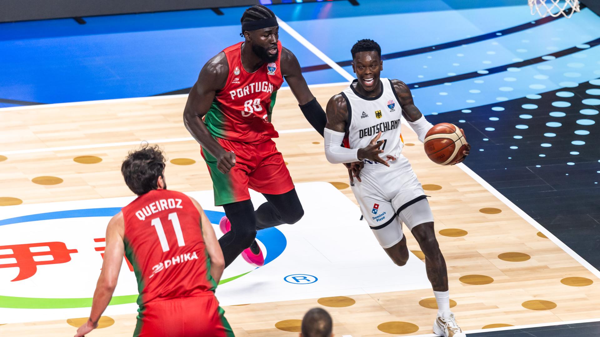 Basketballer Dennis Schröder dribbelt mit dem Ball und wird von einem Gegenspieler verfolgt. Basketballer Dennis Schröder dribbelt mit dem Ball und wird von einem Gegenspieler verfolgt.