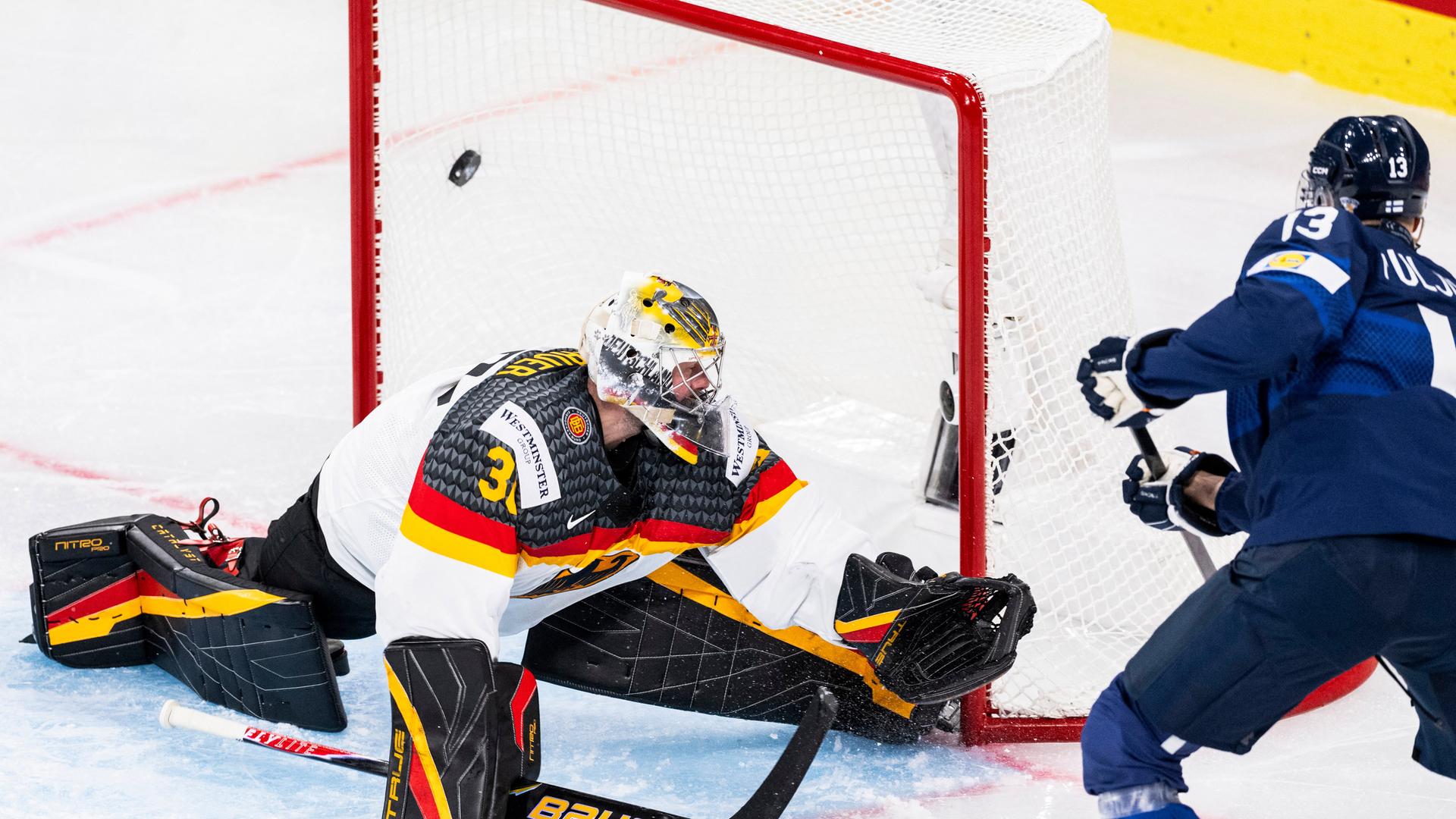 Finnlands Stürmer Jesse Puljujarvi (R) schießt bei der Eishockey-WM ein Tor gegen den deutschen Torhüter Philipp Grubauer (L).
