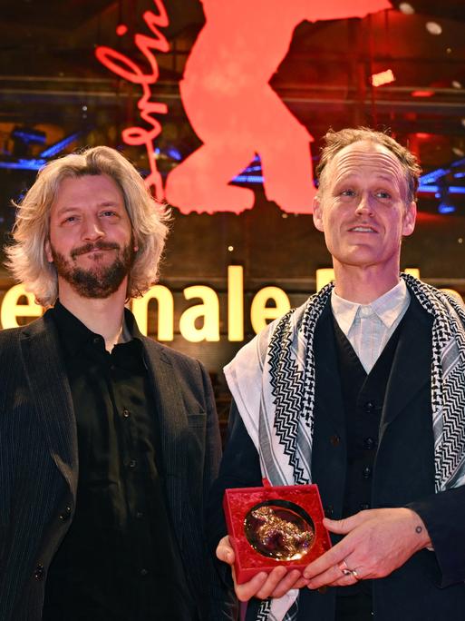 Guillaume Cailleau (r) und Ben Russell stehen mit dem Encounters Preis für den Besten Film für "Direct Action" nach der Preisverleihung der Berlinale 2024 im Berlinale Palast auf dem Roten Teppich.