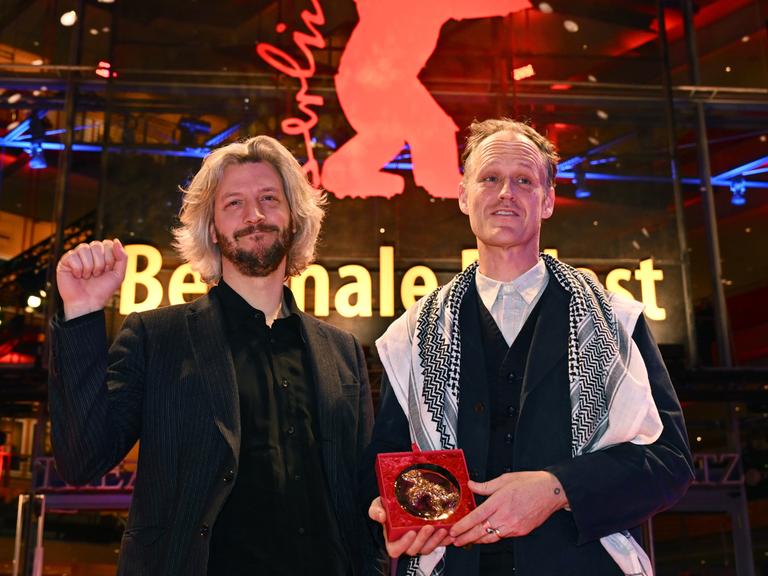Guillaume Cailleau (r) und Ben Russell stehen mit dem Encounters Preis für den Besten Film für "Direct Action" nach der Preisverleihung der Berlinale 2024 im Berlinale Palast auf dem Roten Teppich.