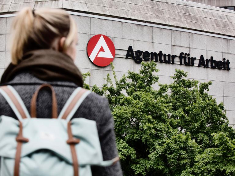 Eine junge Frau auf dem Weg zur Agentur für Arbeit.