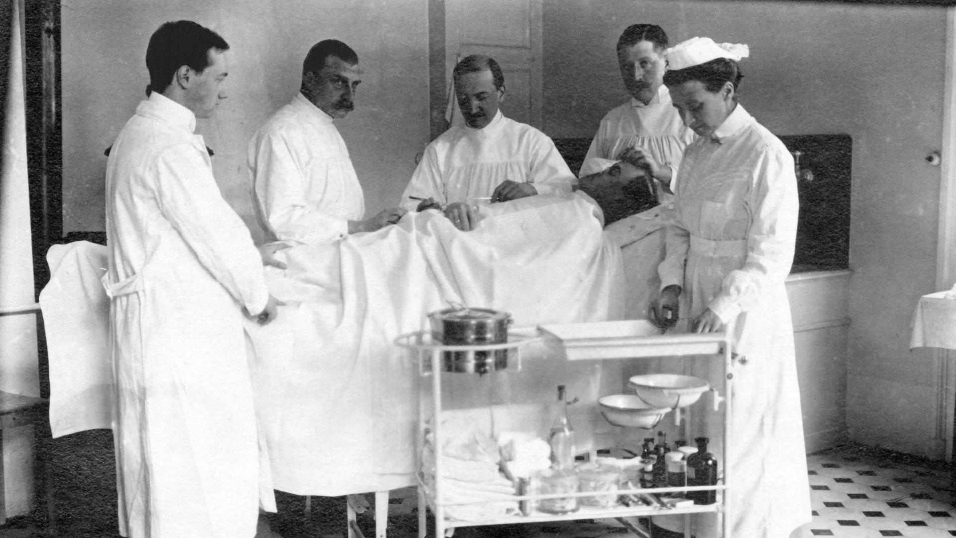 Symbolfoto: Vier Ärzte und eine Krankenschwester während einer Operation in den 1930er Jahren