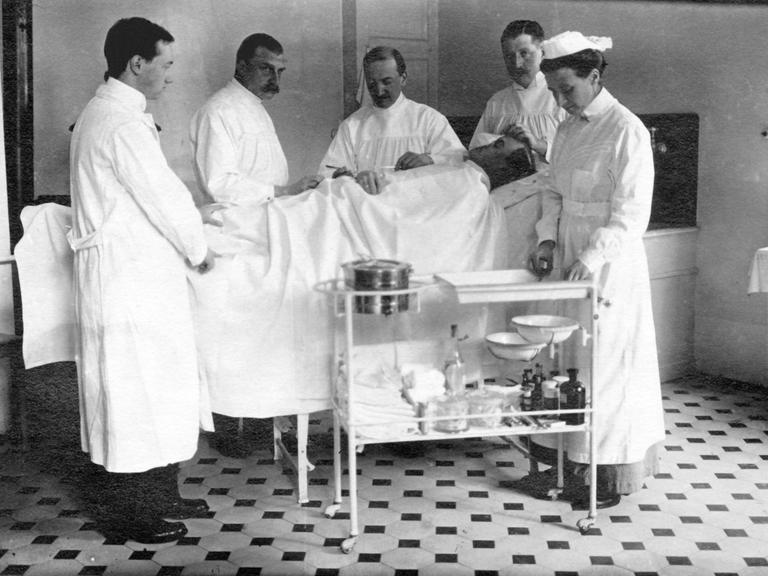 Symbolfoto: Vier Ärzte und eine Krankenschwester während einer Operation in den 1930er Jahren