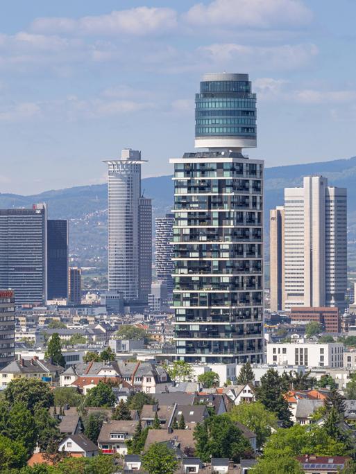 Blick vom Goethetur über den Henninger Turm bis hin zur Frankfurter Skyline. Dazwischen sind kleine Wohnhäuser zu sehen.