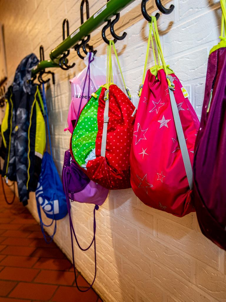An den Kleiderhaken im Flur einer Grundschule hängen Turnbeutel und Jacken der Schulkinder. 