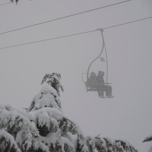Zwei Personen in einem Lift bei einem Schneesturm.