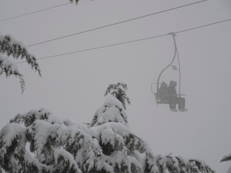 Zwei Personen in einem Lift bei einem Schneesturm.