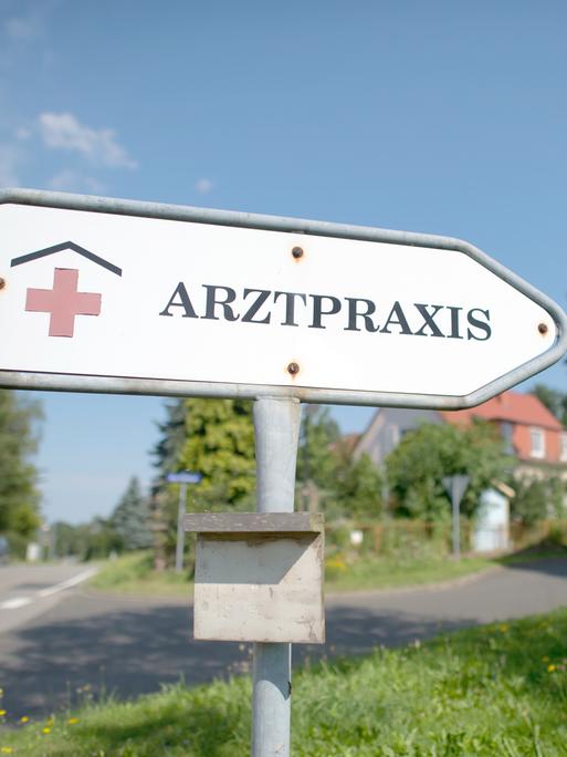 "Arztpraxis" steht auf einem Hinweisschild auf einem Rasen