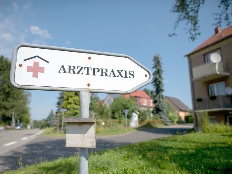 "Arztpraxis" steht auf einem Hinweisschild auf einem Rasen