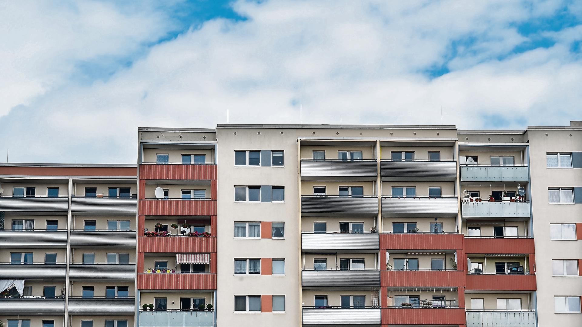 Plattenbauten in der Zossener Straße in Berlin-Hellersdorf: Ein Häuserblock mit Balkonen, die unterschiedliche Farben haben.