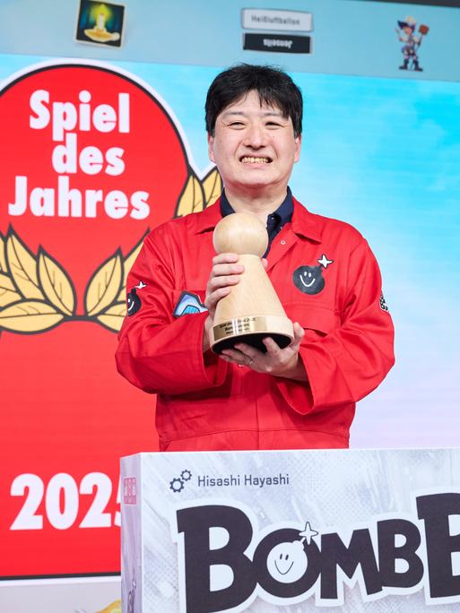Der Designer des Spieles Bomb Busters, Hisashi Hayashi, hält den Hauptpreis bei der Verleihung "Spiel des Jahres" in der Hand.