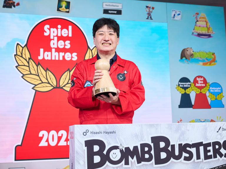 Der Designer des Spieles Bomb Busters, Hisashi Hayashi, hält den Hauptpreis bei der Verleihung "Spiel des Jahres" in der Hand.