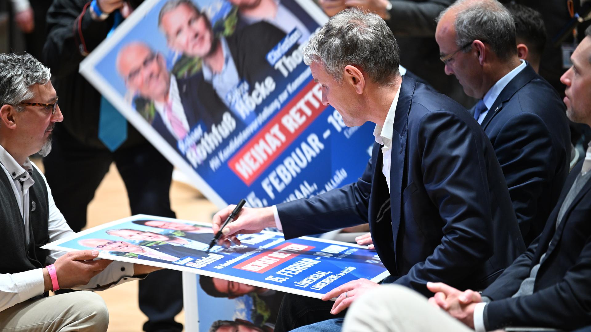 Der thüringische AfD-Vorsitzende Björn Höcke signiert im Löwensaal vor seiner Rede ein paar Wahlplakate für seine Anhänger. 