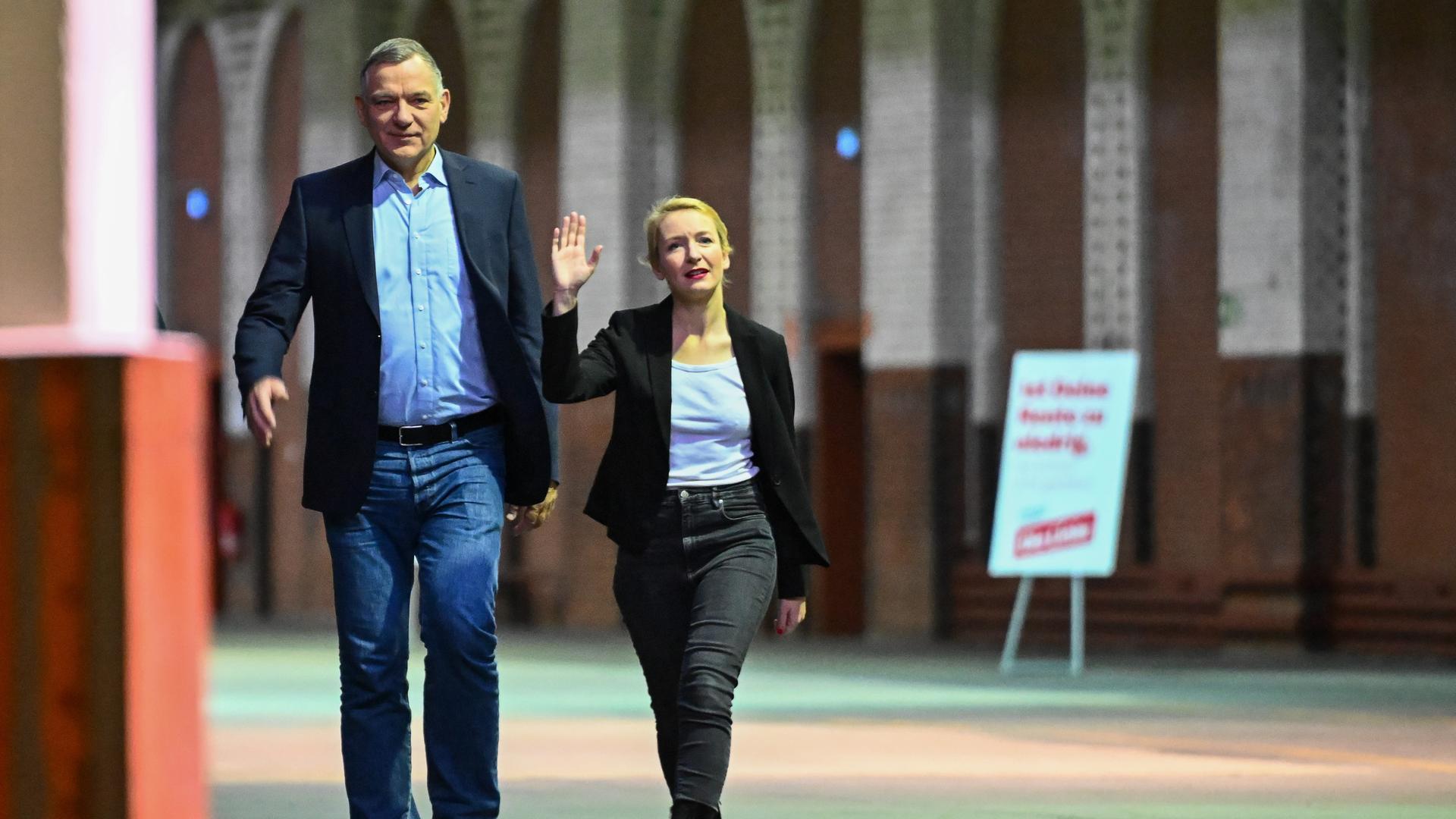 Jan van Aken und Ines Schwerdtner, die beiden Bundesvorsitzende der Partei Die Linke, gehen vor Beginn des Bundesparteitags durch die Halle.