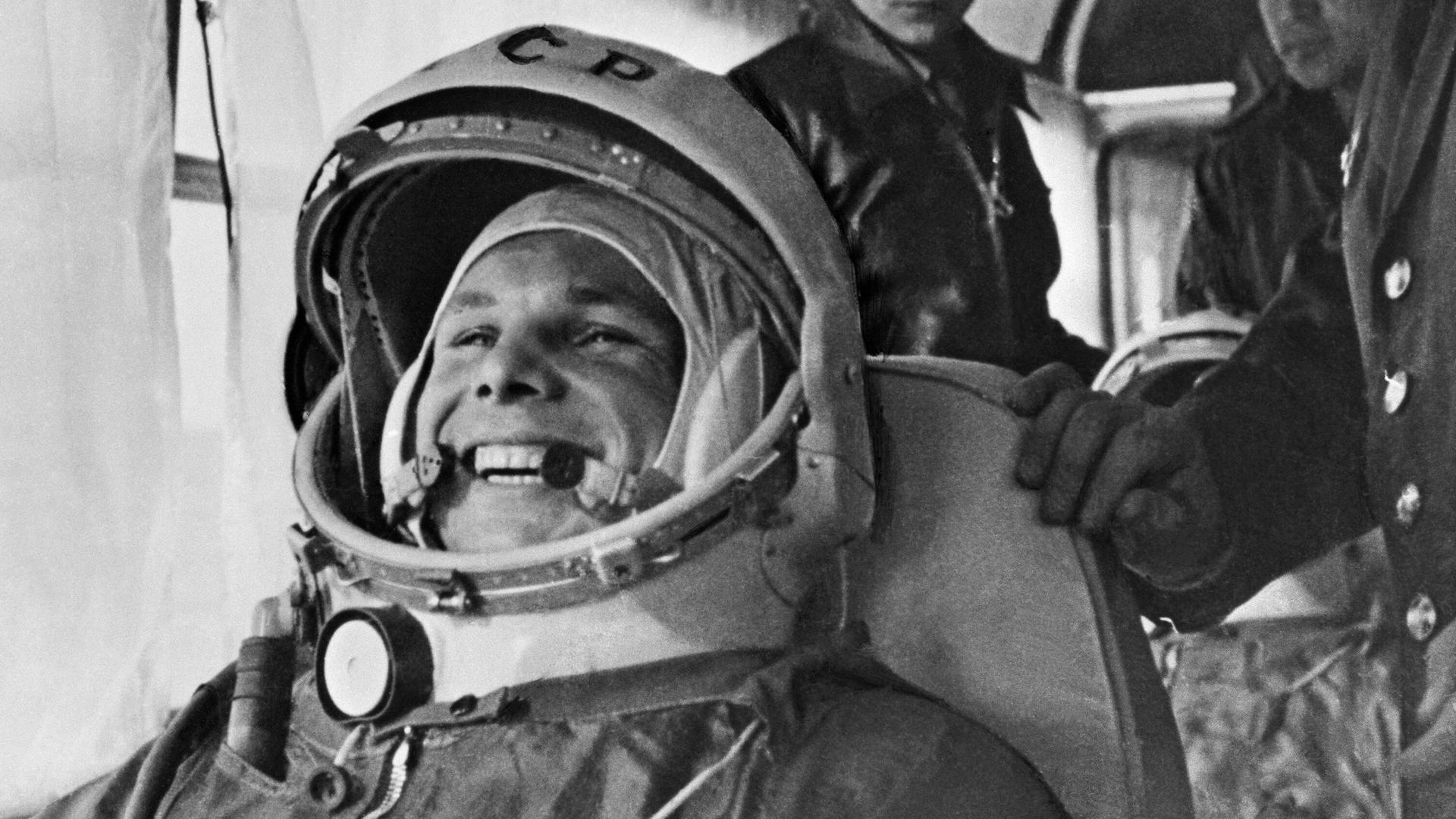 Schwarzweißaufnahme von Juri Gagarin in Astronautenmontur. Er lacht.