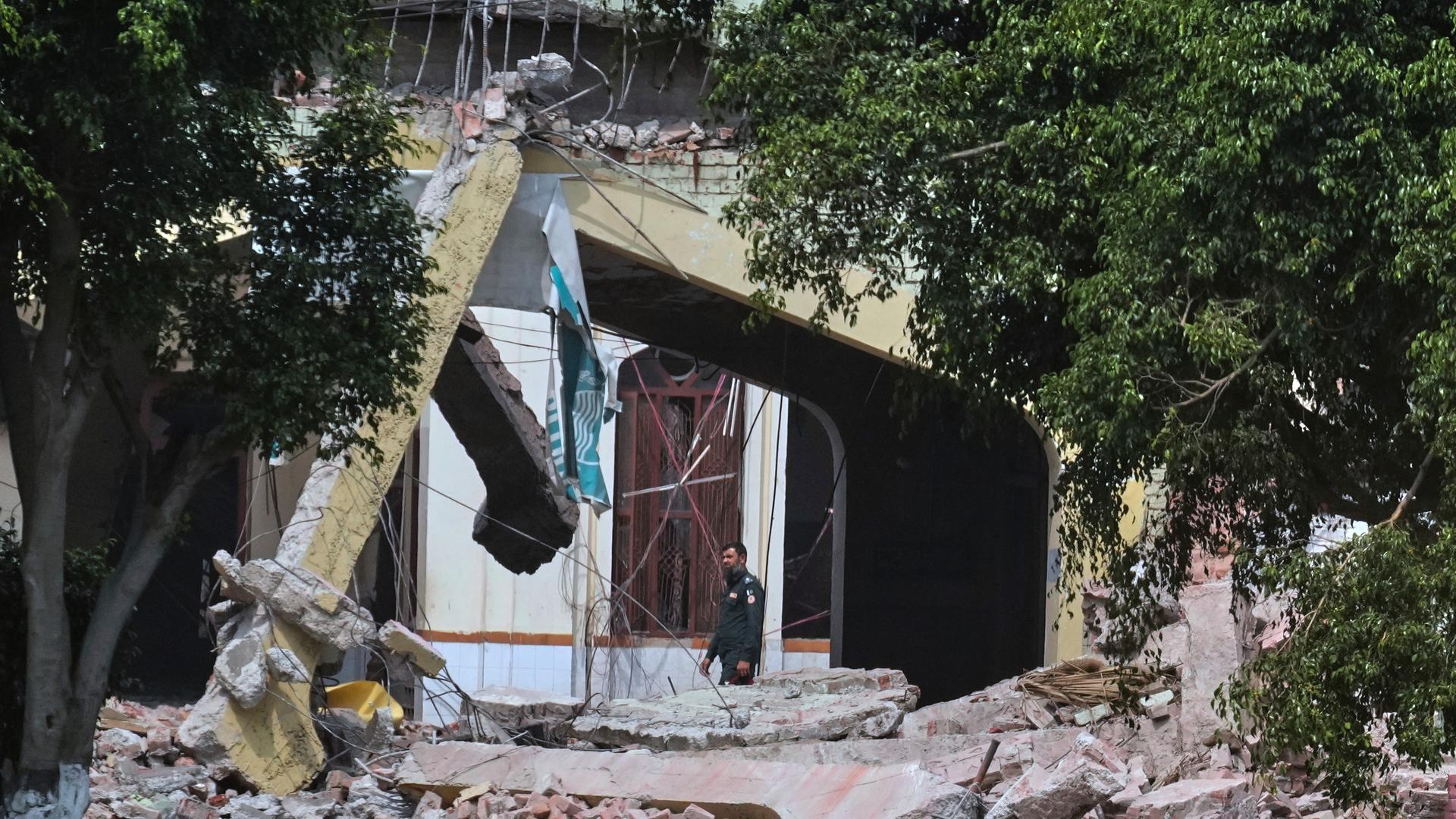Ein Wachmann geht durch die Trümmer eines beschädigten Gebäudes nach einem mutmaßlichen indischen Raketenangriff in Muridke, Provinz Punjab in Pakistan. Ein Wachmann geht durch die Trümmer eines beschädigten Gebäudes nach einem mutmaßlichen indischen Raketenangriff in Muridke, Provinz Punjab in Pakistan.