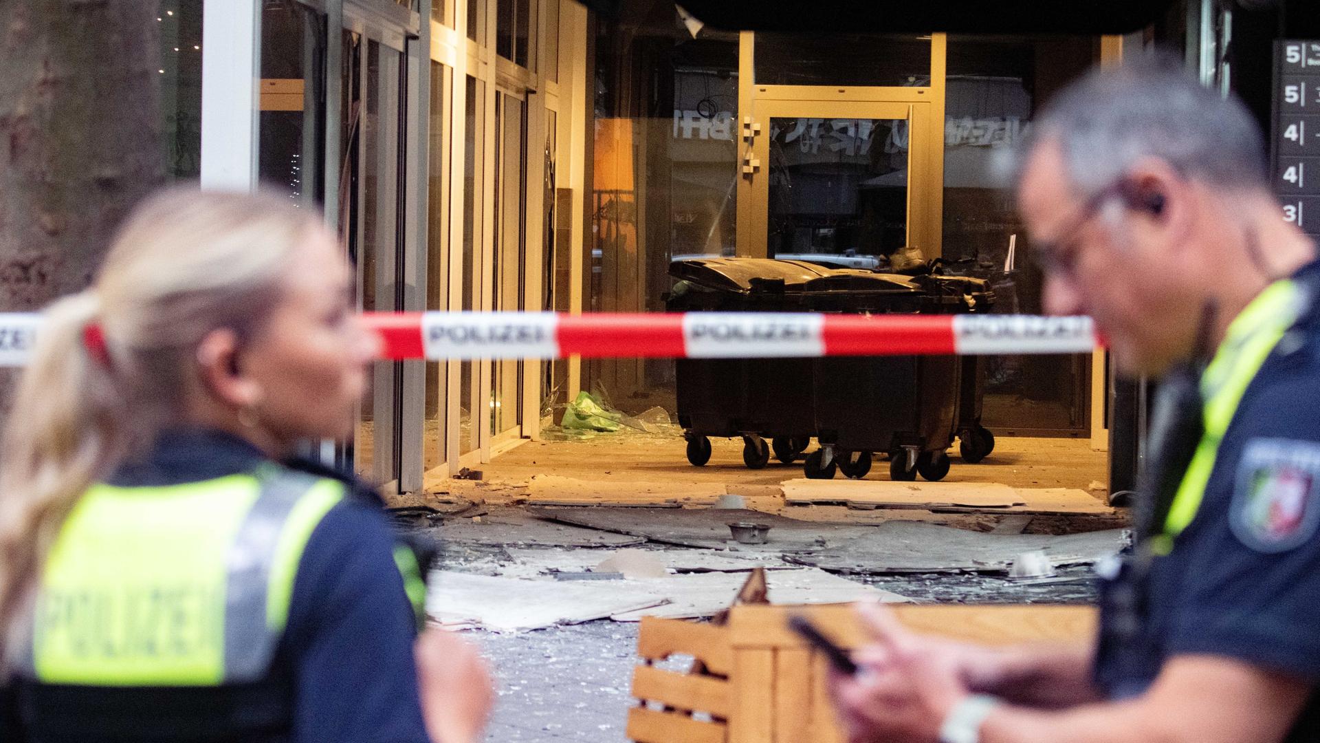 Polizeibeamte stehen nach einer Explosion vor einem beschädigten Gebäude in der Innenstadt am Hohenzollernring in Köln. 