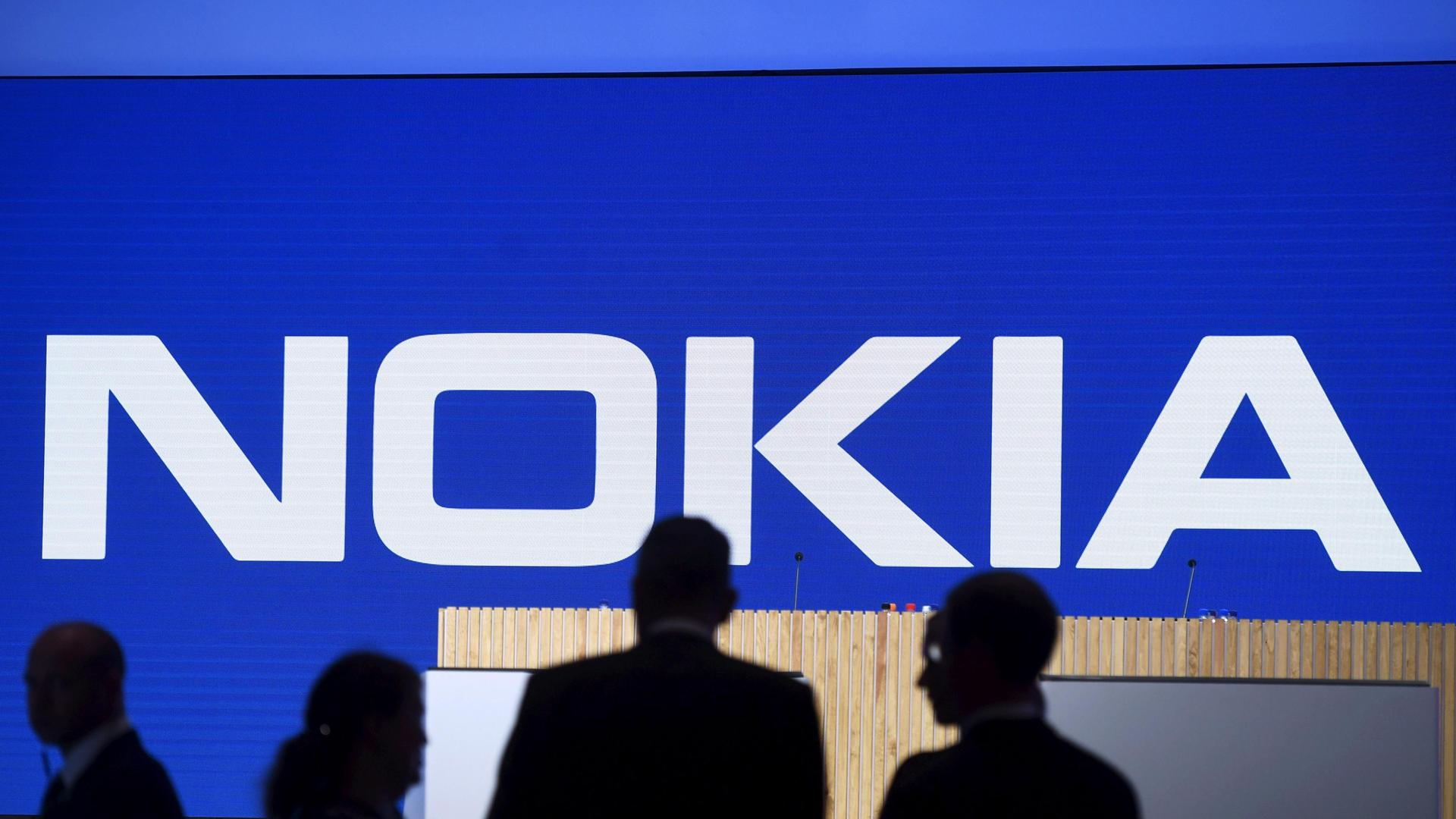 Der Schriftzug von Nokia ist zu sehen. Davor vier dunkle Schatten. Der Schriftzug von Nokia ist zu sehen. Davor vier dunkle Schatten.