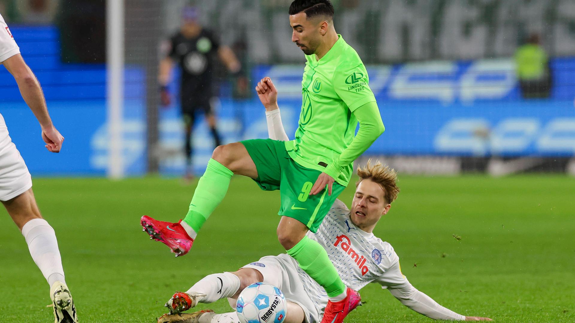 Finn Porath von Holstein Kiel und Mohamed Amoura vom VfL Wolfsburg kämpfen um den Ball.