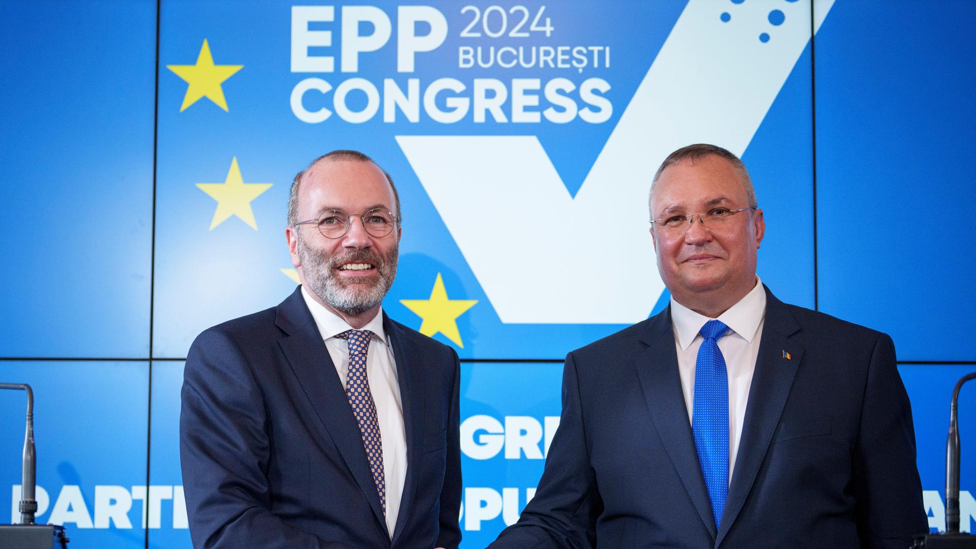 Manfred Weber (l), Vorsitzender der Europäischen Volkspartei, gibt Nicolae Ciuca, Vorsitzender der rumänischen Liberalen Partei, nach einer gemeinsamen Pressekonferenz anlässlich des Kongresses der Europäischen Volkspartei in Bukarest die Hand.