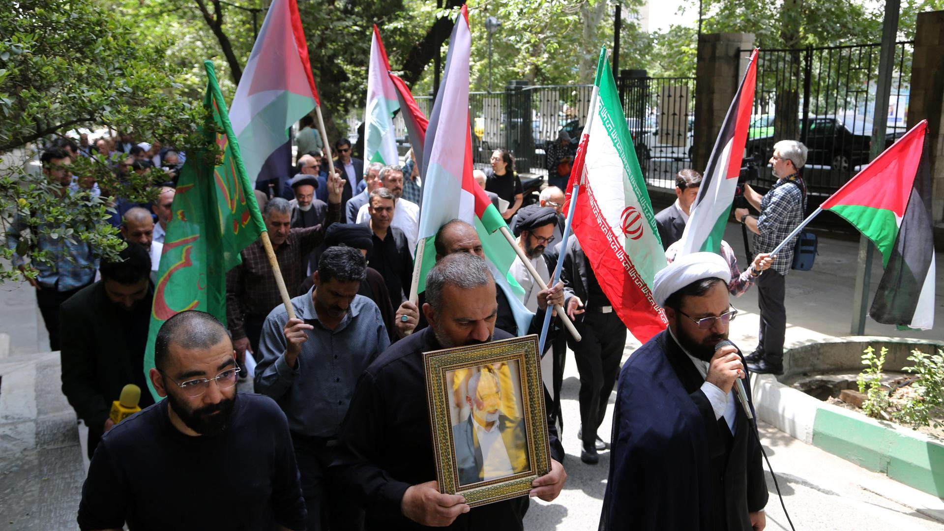 Akademiker der Teheraner Universität schwenken bei einer Demonstration anlässlich der Tötung von Hamas-Chef Ismail Hanija Palästina- und Iran-Flaggen und halten ein Bild des Verstorbenen.