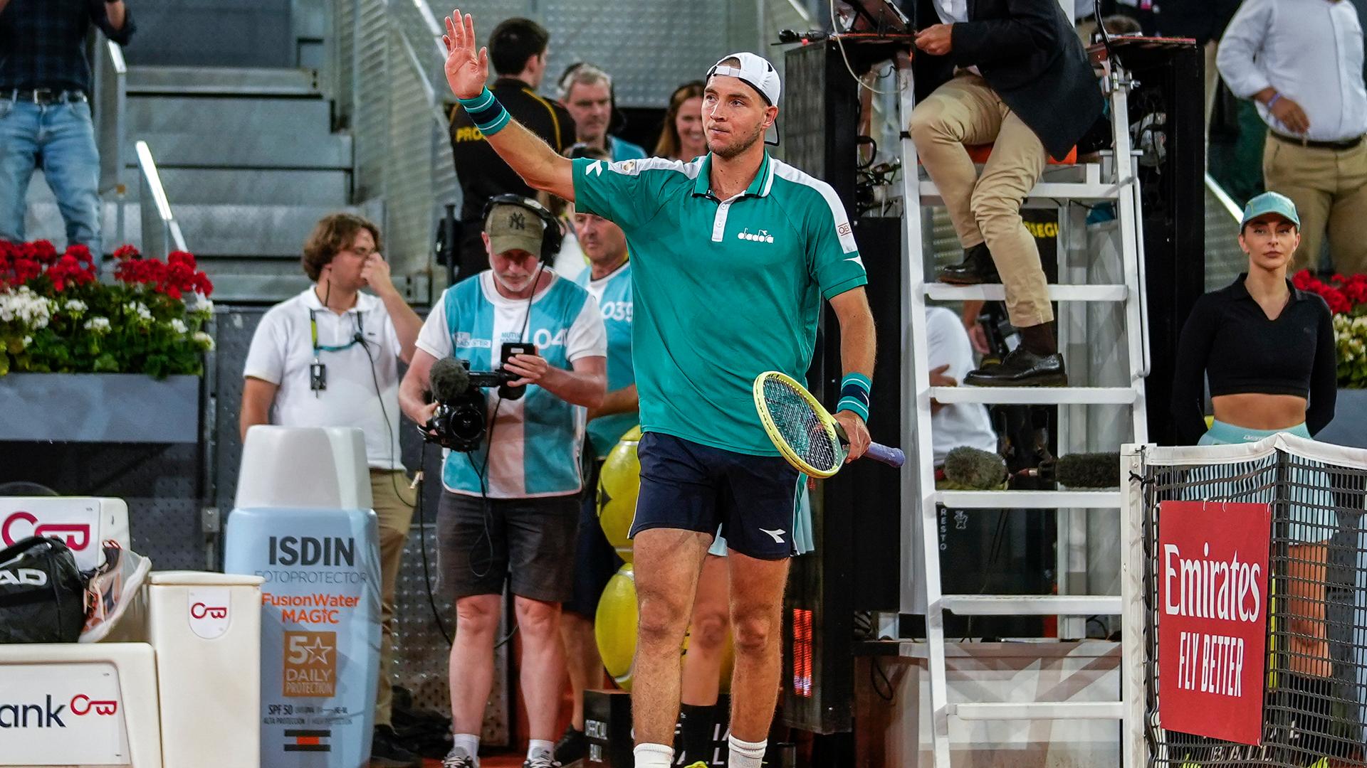 Tennisspieler Jan-Lennard Struff steht auf dem Spielfeld und winkt mit der rechten Hand ins Publikum.