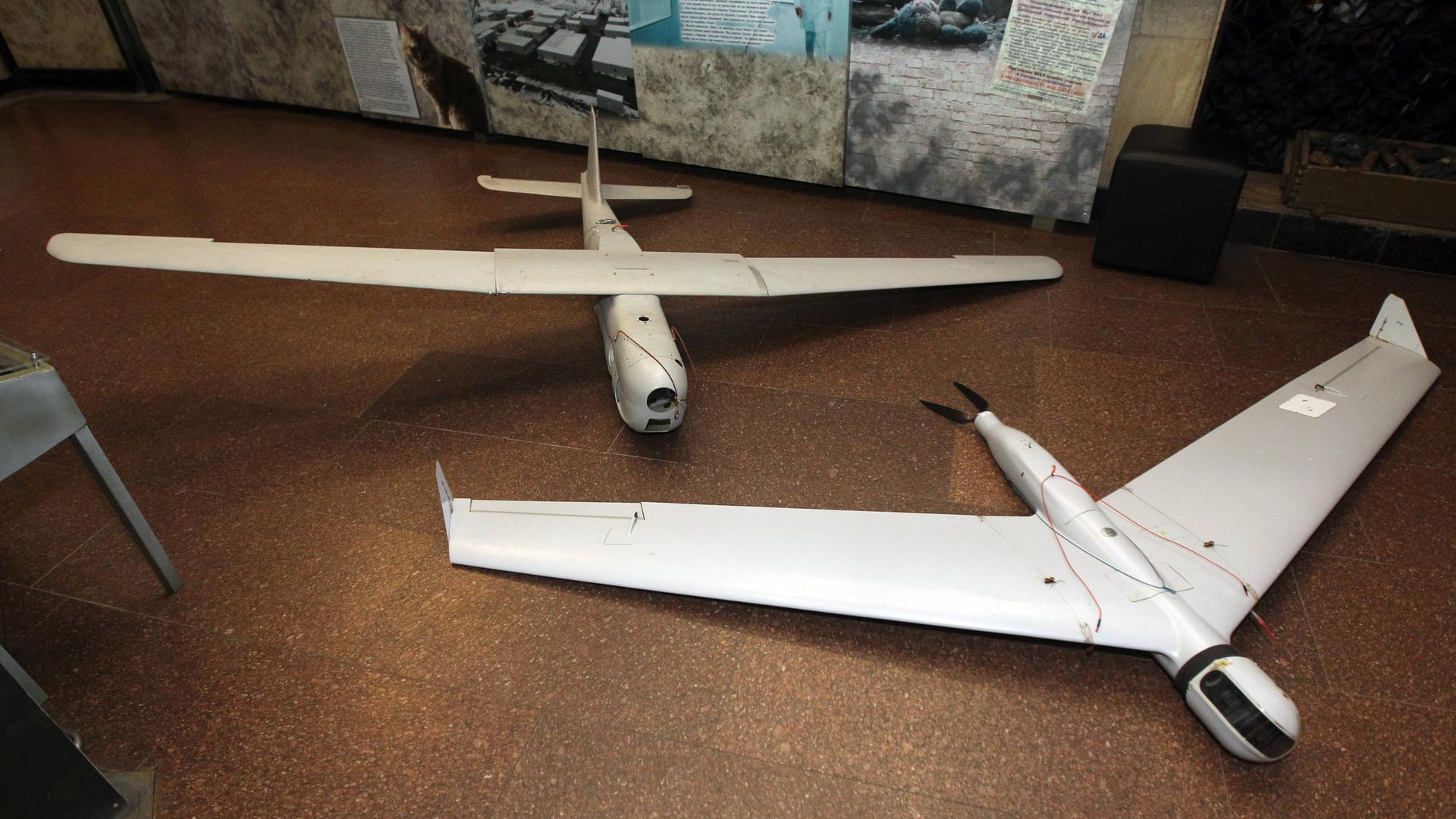 Zwei abgeschossene russische Drohnen liegen in einem Museum in Dnipro auf dem Boden nebeneinander.