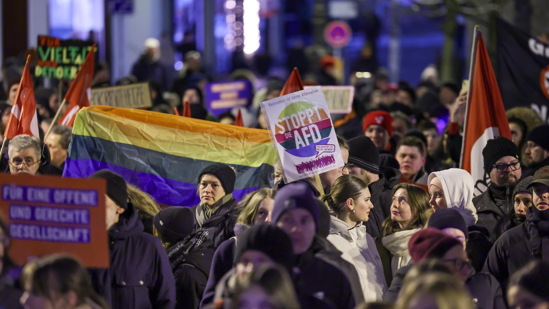 Eine Menschenmenge demonstriert u.a. mit Regenbogenflagge und einem Plakat mit der Aufschrift "Stoppt die AfD".
