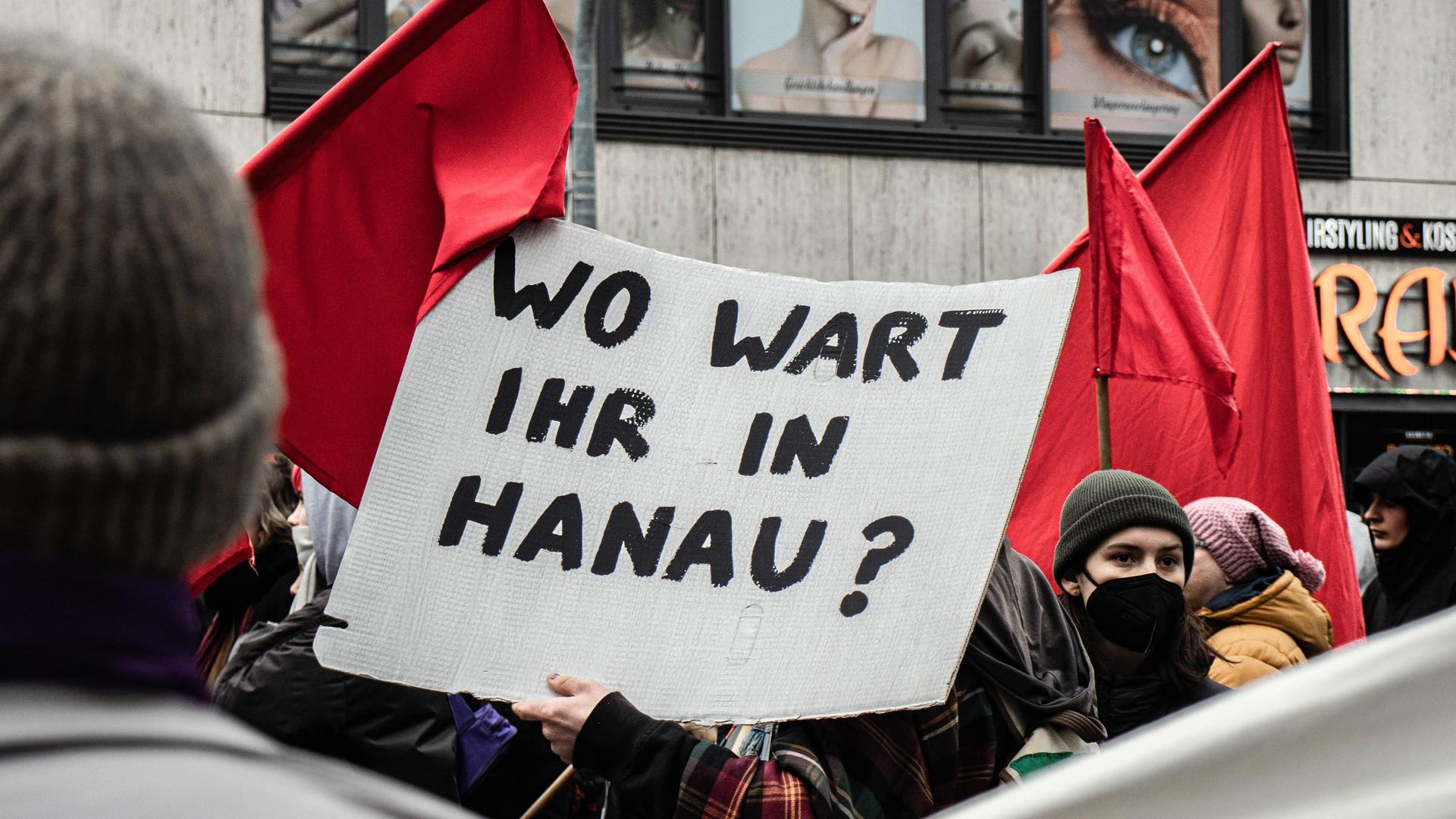 Zu sehen ist eine Menschenmenge und mittig ein Plakat mit der Aufschrift: "Wo wart ihr in Hanau?" Gedenken an Opfer des Hanau-Anschlages in München: Am 19. Februar 2023 versammelten sich am Königsplatz in München 500 Personen zu einer Demonstration, um den Opfern des rassistischen Terror-Anschlags in Hanau im Jahr 2020 zu gedenken. Nach der Zwischenkundgebung wurde Pyrotechnik verwendet.