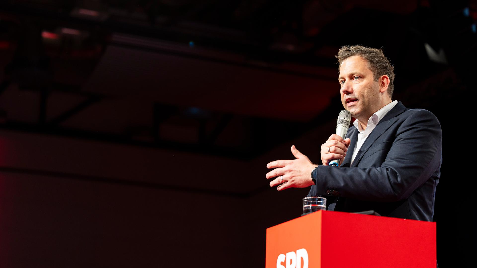 Lars Klingbeil spricht beim Landesparteitag der SPD Niedersachsen in Wolfenbüttel. Er trägt einen dunklen Anzug und steht an einem roten Rednerpult mit weißem SPD-Logo. In der Hand hält er ein Mikrofon.