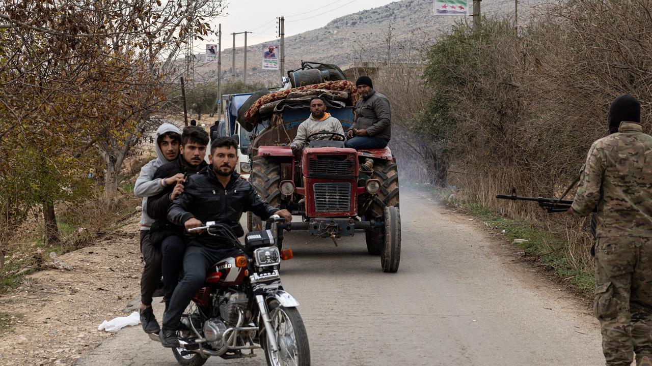 Syrische Kurden sitzen in Autos und auf Mopeds auf der Flucht aus dem syrischen Norden.