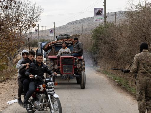 Syrische Kurden sitzen in Autos und auf Mopeds auf der Flucht aus dem syrischen Norden.