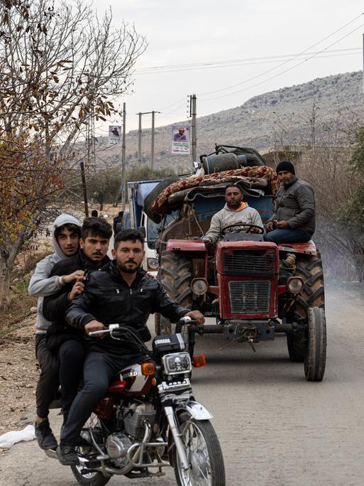 Syrische Kurden sitzen in Autos und auf Mopeds auf der Flucht aus dem syrischen Norden.