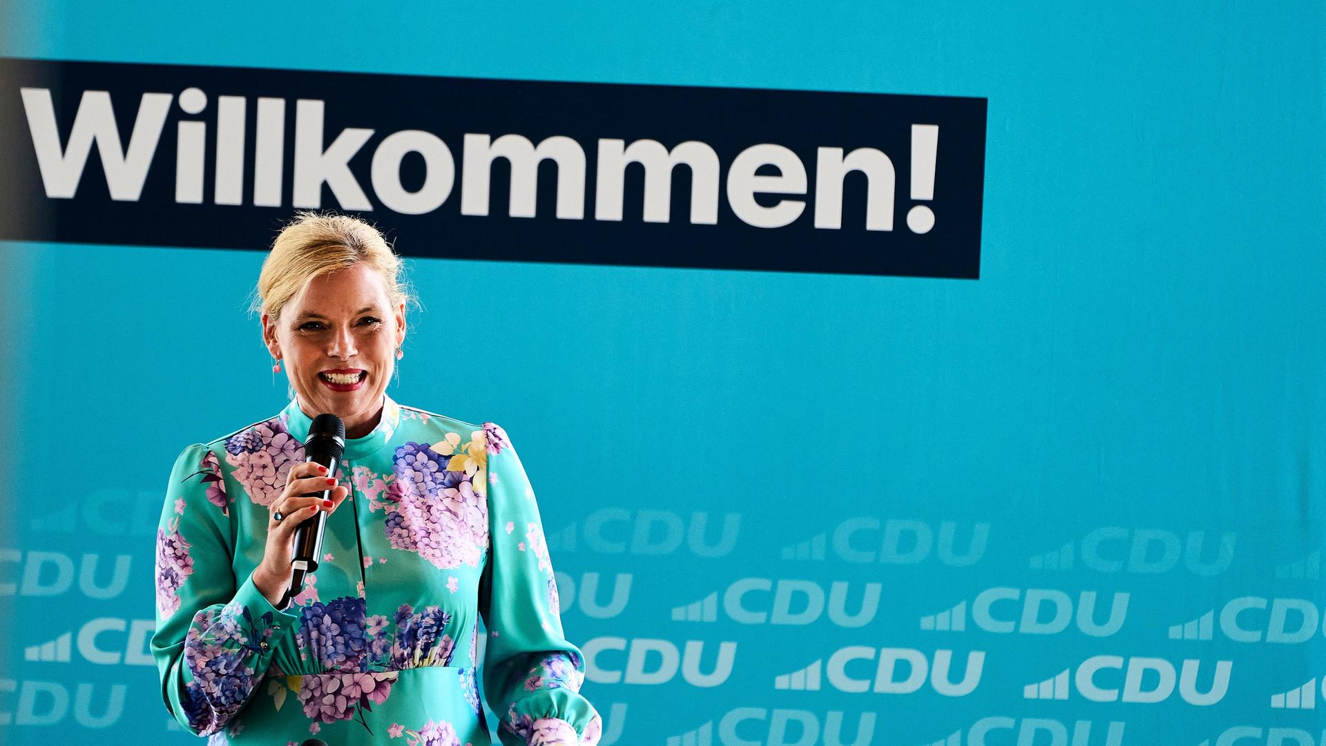 Bundestagspräsidentin Julia Klöckner (CDU) hält eine Rede beim CDU-Sommerfest in Koblenz. Sie trägt ein türkises Blumenkleid. 