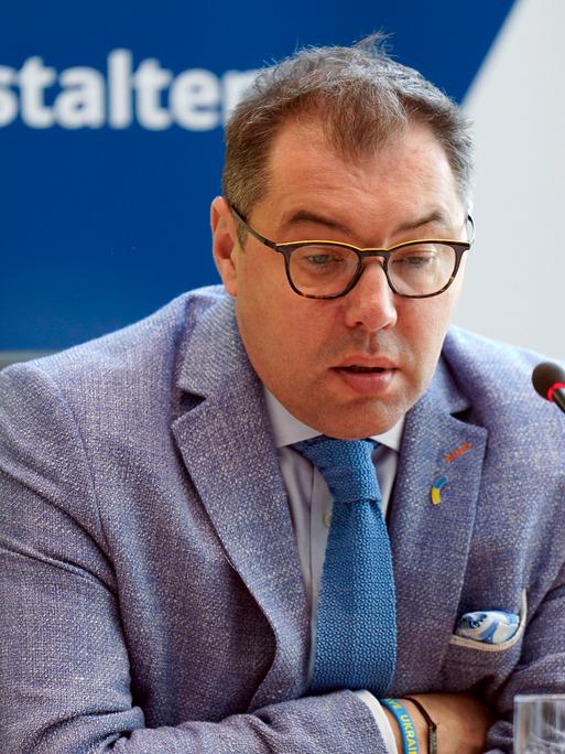 Oleksii Makeiev, ukrainischer Botschafter in Deutschland bei sitzt mit gesenktem Blick vor einem Mikrofon