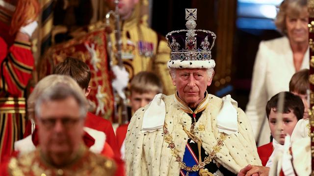 König Charles III. von Großbritannien trägt die kaiserliche Staatskrone und den Staatsmantel während der Eröffnung des Parlaments im House of Lords im Palace of Westminster.