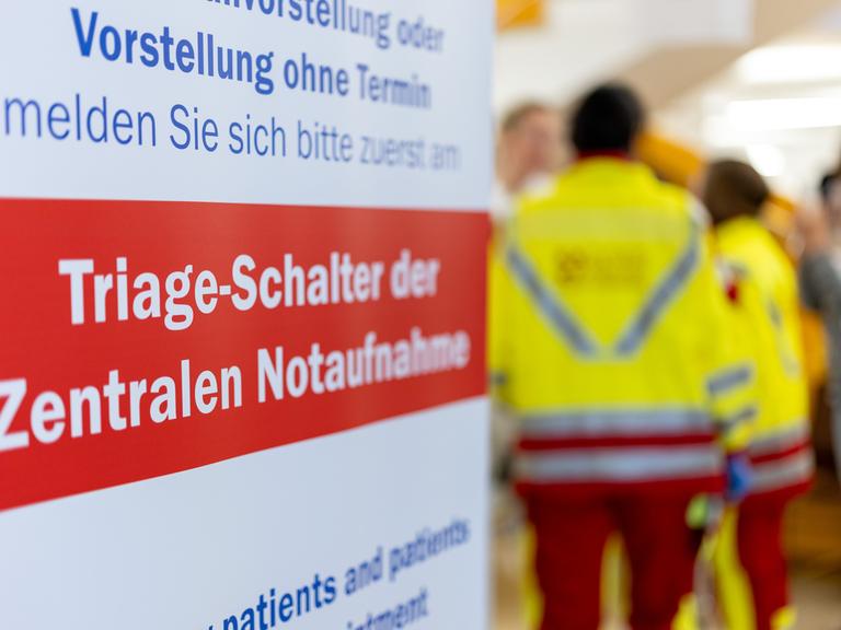 "Triage-Schalter der Zentralen Notaufnahme" steht auf einem Banner, im Hintergrund stehen Rettungskräfte.