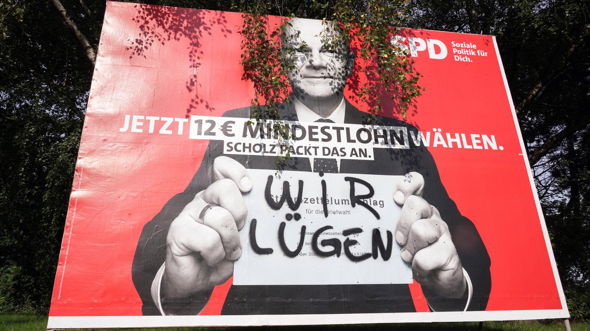 "Wir lügen" steht in Sprühfarbe auf einem Wahlplakat von SPD-Kanzlerkandidat Olaf Scholz (2021)