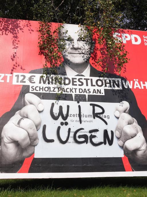 "Wir lügen" steht in Sprühfarbe auf einem Wahlplakat von SPD-Kanzlerkandidat Olaf Scholz (2021)