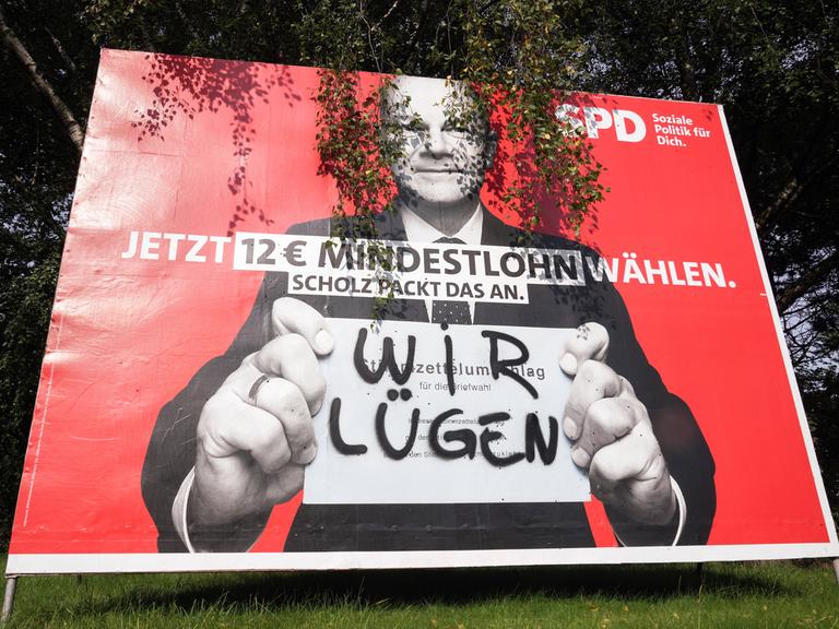 "Wir lügen" steht in Sprühfarbe auf einem Wahlplakat von SPD-Kanzlerkandidat Olaf Scholz (2021)