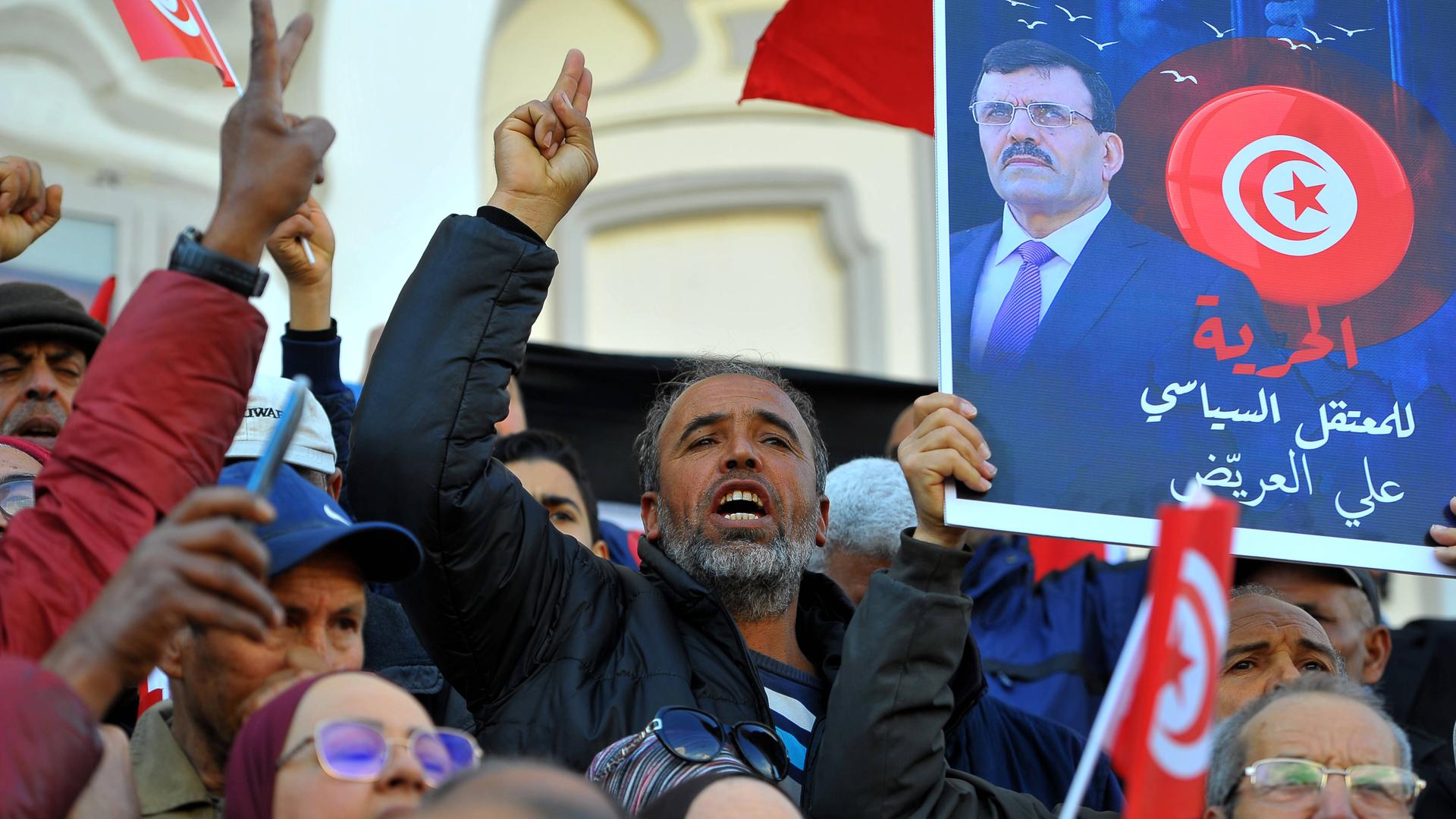 Antiregierungsproteste in Tunesien: Menschen demonstrieren, skandieren, halten Schilder hoch.