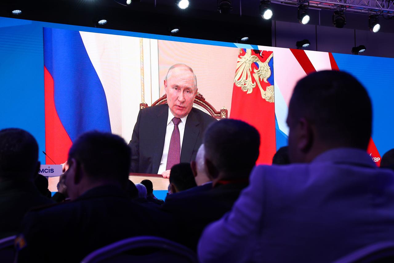 Presiden Rusia Vladimir Putin menyampaikan pesan video kepada penonton di auditorium