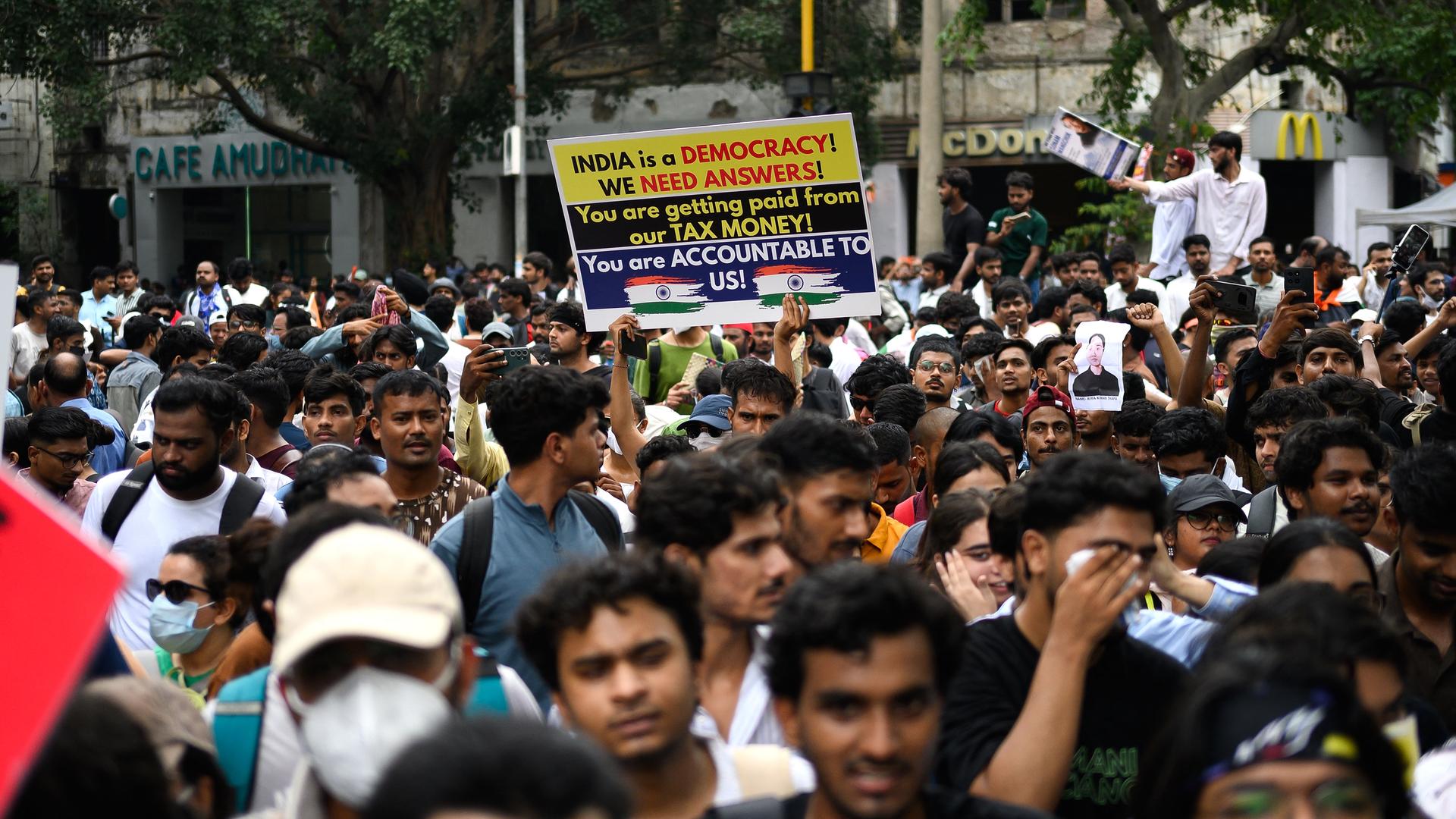 Aktivisten und Mitglieder der Kakerlaken-Partei halten in Neu Delhi Plakate hoch. Aktivisten und Mitglieder der Kakerlaken-Partei halten in Neu Delhi Plakate hoch.