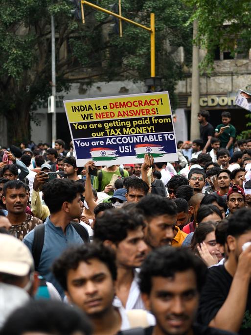 Aktivisten und Mitglieder der Kakerlaken-Partei halten in Neu Delhi Plakate hoch.