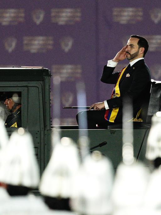 Der neue kolumbianische Präsident Abelardo de la Espriella nimmt nach seiner Amtseinführung in der Stadt Cali salutierend eine Militärparade ab. Im Vordergrund sind Helme zu sehen.  