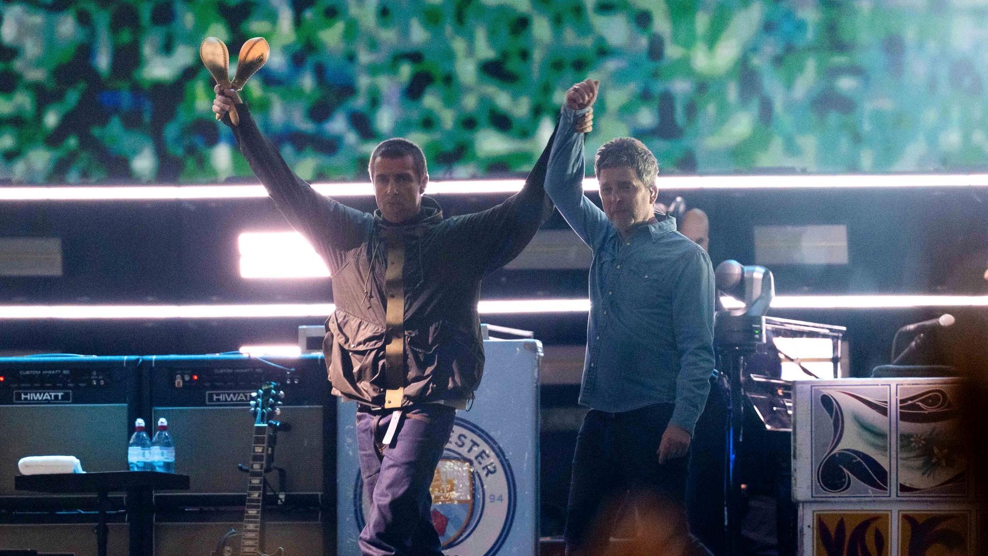 Liam Gallagher (l.), hält die Hand von Noel Gallagher von der Band Oasis während ihres Reunion-Konzerts am Freitag, 4. Juli 2025, in Cardiff Liam Gallagher (l.), hält die Hand von Noel Gallagher von der Band Oasis während ihres Reunion-Konzerts am Freitag, 4. Juli 2025, in Cardiff