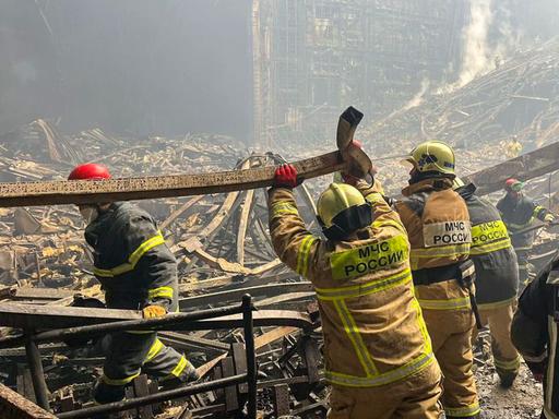 Feuerwehrleute räumen Trümmer beiseite auf dem Gelände der von einem Anschlag getroffenen Crocus City Hall.  (Russisches Katastrophenschutzministerium/Tass)
