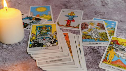 Tarotkarten mit einer brennenden weißen Kerze