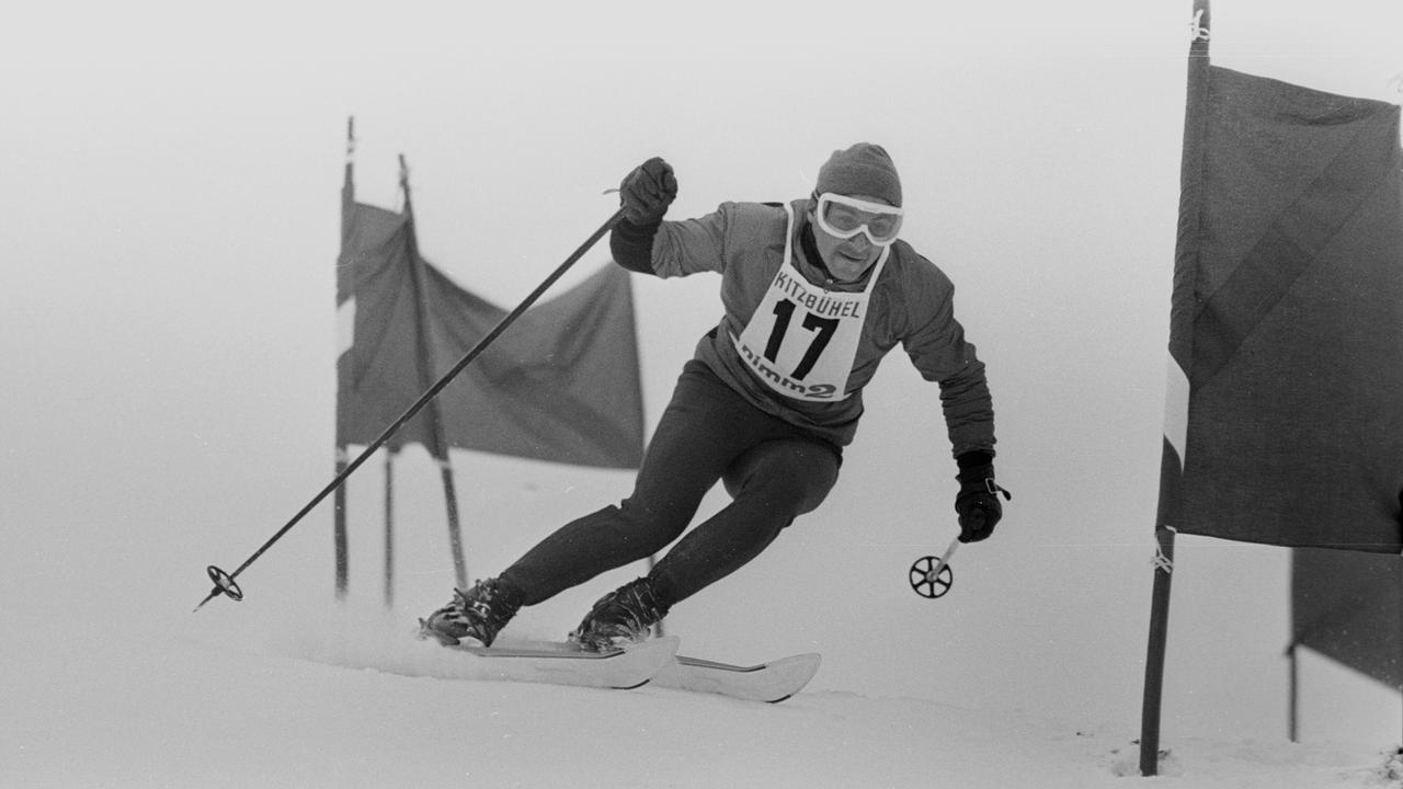 Schwarzweiß-Aufnahme von Skirennläufer Eberhard Riedel aus dem Jahr 1965. Er fährt eine Piste in Kitzbühel herunter und trägt ein Trikot mit der Startnummer 17.