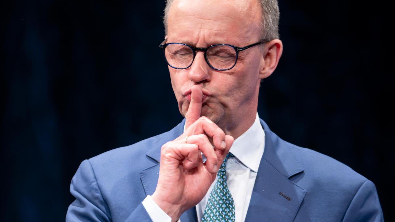 Friedrich Merz legt als "Ruhe-Zeichen" den Finger auf die Lippen